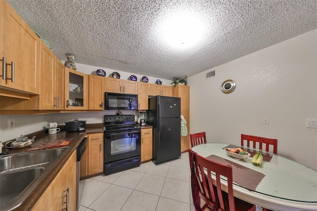 kitchen featuring sink, black appliances, a textured ceiling, and light tile patterned flooring