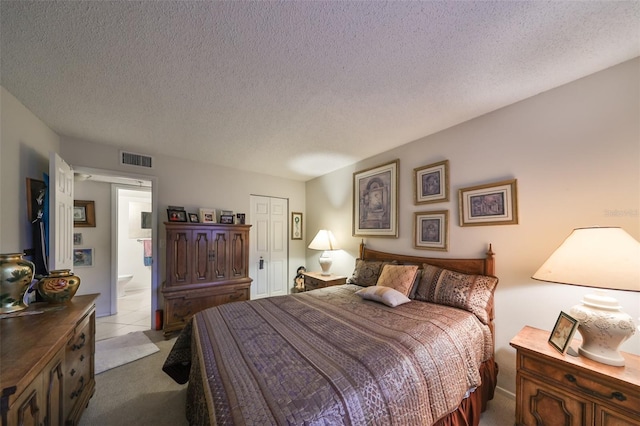 bedroom featuring light carpet, a closet, a textured ceiling, and ensuite bathroom