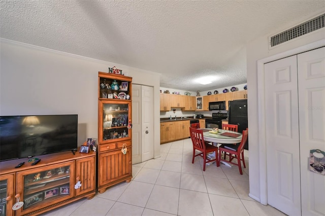 dining area with crown molding, sink, light tile patterned floors, and a textured ceiling