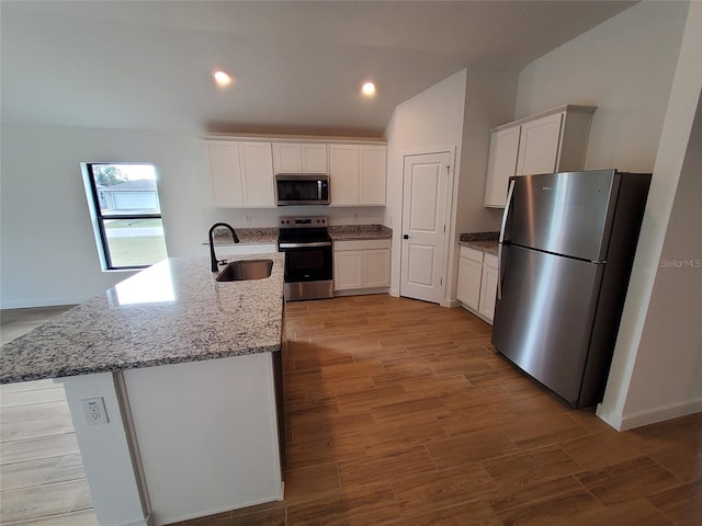 kitchen featuring an island with sink, appliances with stainless steel finishes, sink, and white cabinets