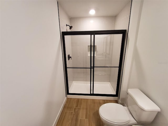 bathroom with a shower with door and toilet