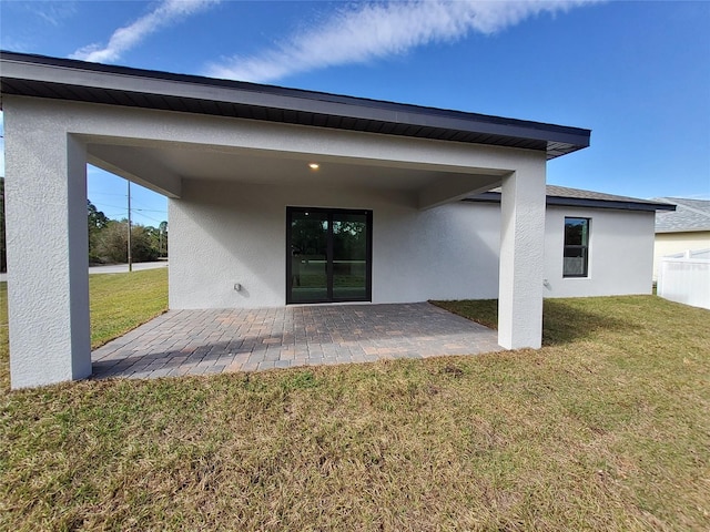 back of house with a yard and a patio