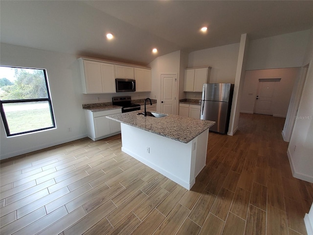 kitchen featuring sink, white cabinets, stainless steel fridge, a kitchen island with sink, and black range with electric cooktop