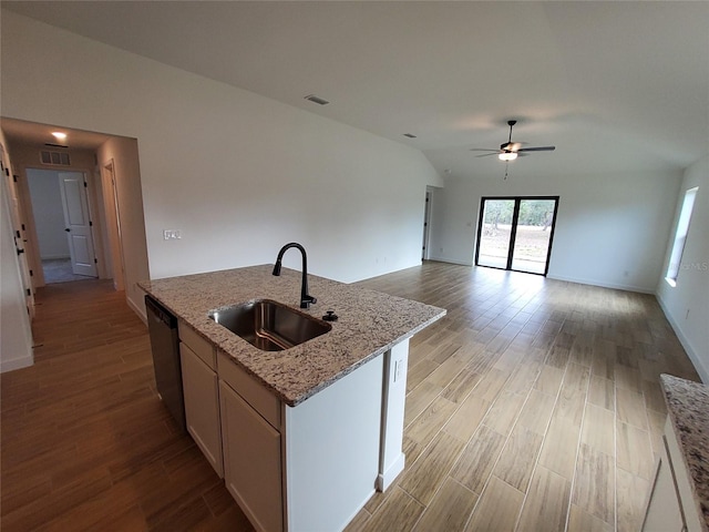 kitchen featuring sink, dishwasher, a kitchen island with sink, light stone counters, and white cabinets