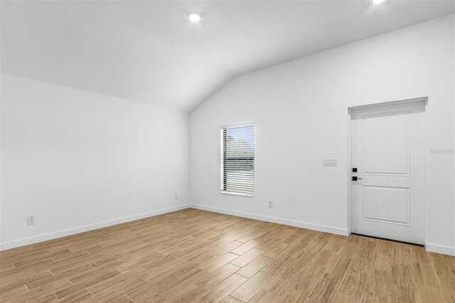 5710 Humkey St, North Port, FL 34291 - spare room with baseboards, vaulted ceiling, and light wood-style floors