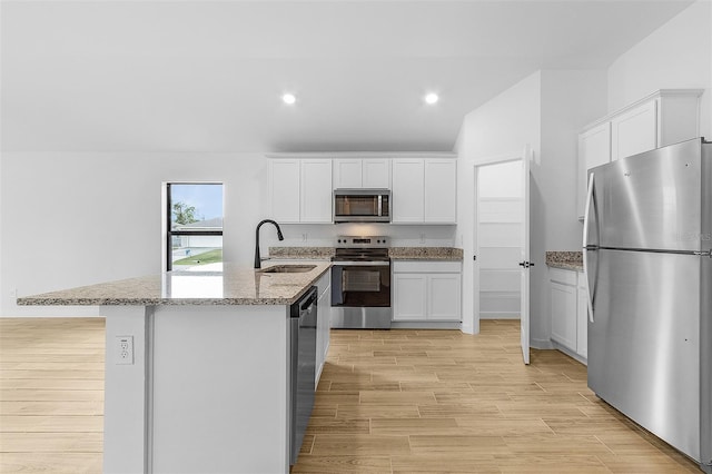5710 Humkey St, North Port, FL 34291 - kitchen with light stone counters, a sink, light wood finished floors, stainless steel appliances, and white cabinets