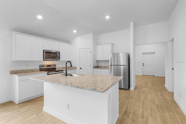 5710 Humkey St, North Port, FL 34291 - kitchen with white cabinets, a center island with sink, appliances with stainless steel finishes, a sink, and light wood-type flooring