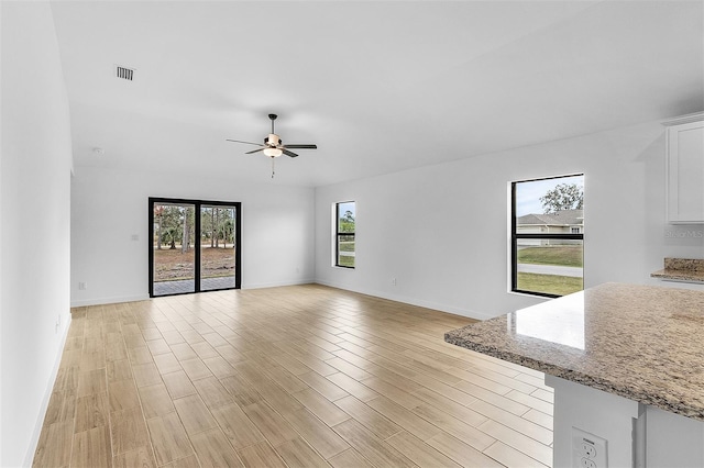 5710 Humkey St, North Port, FL 34291 - unfurnished living room featuring baseboards, light wood-type flooring, visible vents, and a ceiling fan