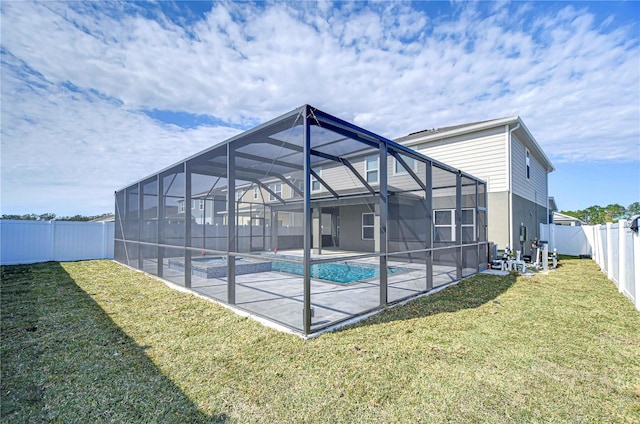 exterior space featuring glass enclosure, a fenced in pool, a patio area, and a lawn