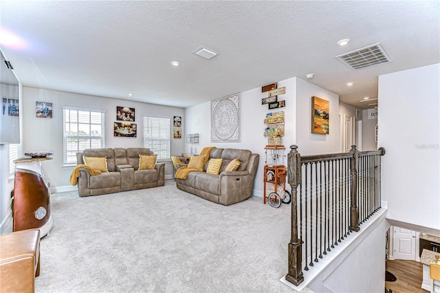 carpeted living room featuring a textured ceiling