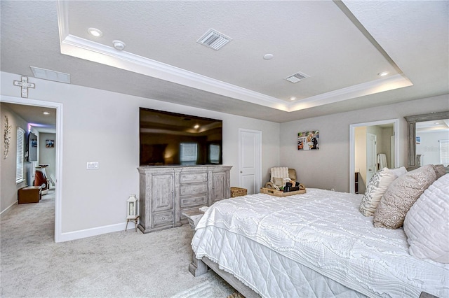 carpeted bedroom featuring crown molding and a tray ceiling