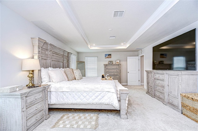 bedroom featuring light colored carpet, ornamental molding, and a tray ceiling