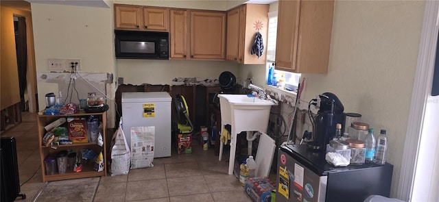 kitchen with light tile patterned flooring, radiator heating unit, and refrigerator