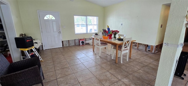 tiled dining area with lofted ceiling