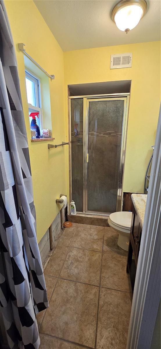 bathroom featuring a shower, vanity, and toilet