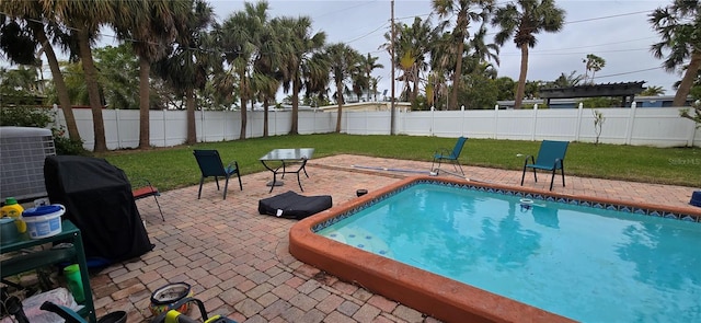 view of swimming pool with a yard, a patio area, and central air condition unit