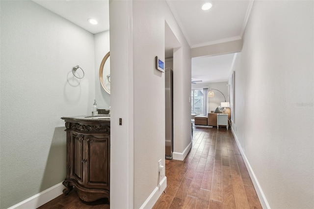 hallway with ornamental molding and hardwood / wood-style floors