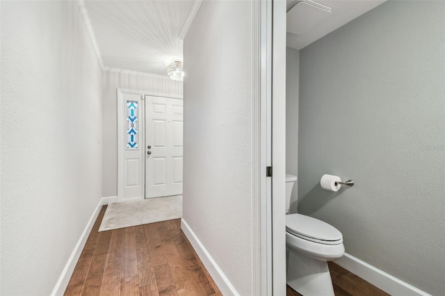 bathroom with crown molding, hardwood / wood-style floors, and toilet