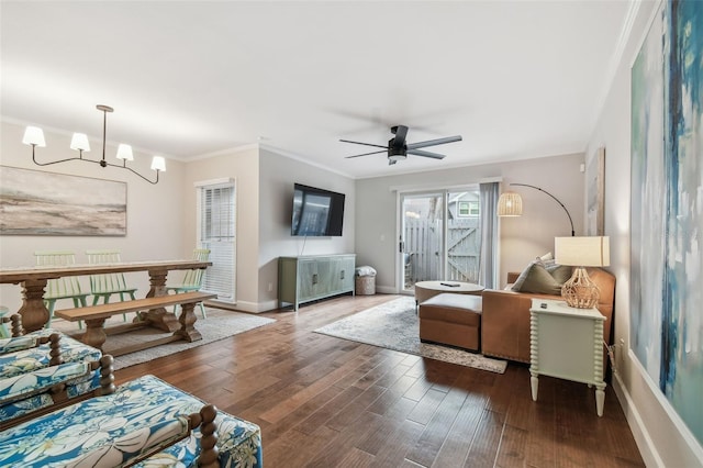 living room featuring ornamental molding, dark hardwood / wood-style floors, and ceiling fan with notable chandelier