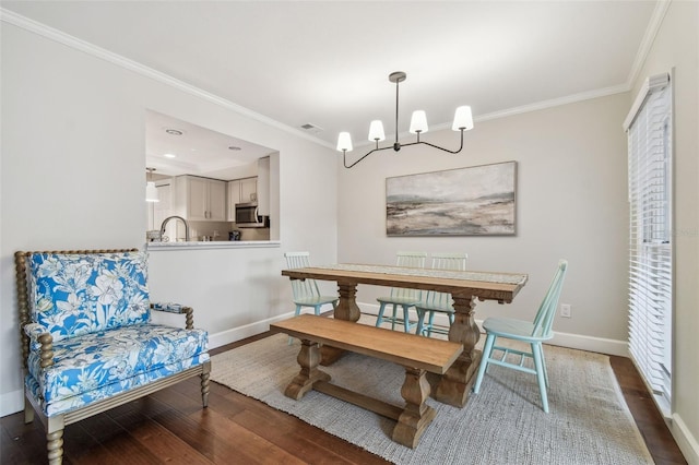 dining space featuring crown molding, dark wood-type flooring, sink, and a notable chandelier