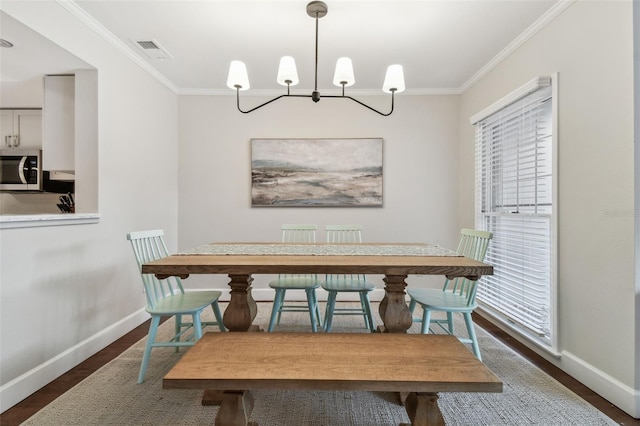 dining area featuring crown molding, a chandelier, and dark wood-type flooring