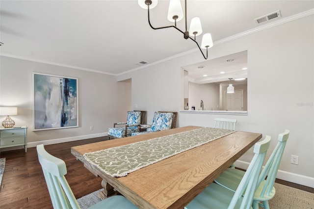 dining area featuring crown molding, dark hardwood / wood-style floors, and a chandelier