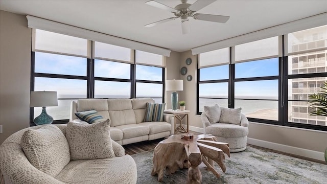 living room featuring a water view, ceiling fan, and hardwood / wood-style flooring