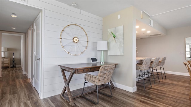 office featuring dark wood-type flooring and wooden walls