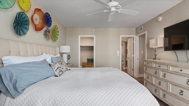 bedroom with ceiling fan, a spacious closet, dark hardwood / wood-style flooring, and a closet