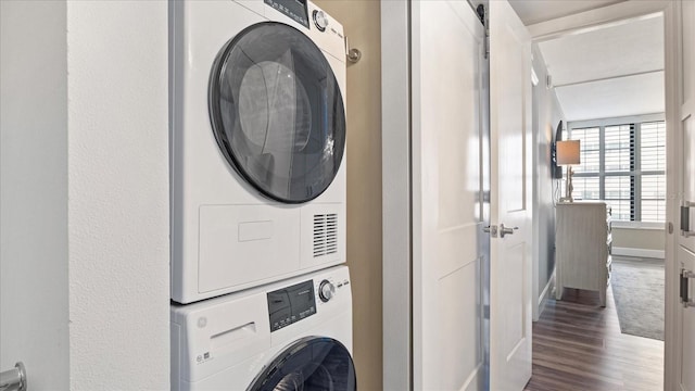 clothes washing area with stacked washer and clothes dryer and hardwood / wood-style floors