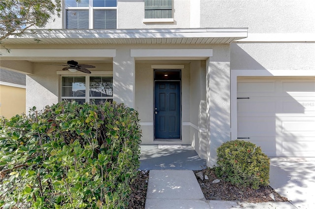 doorway to property with a garage and ceiling fan