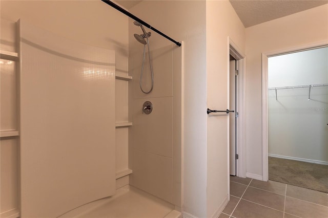 bathroom featuring tile patterned flooring, a textured ceiling, and a shower