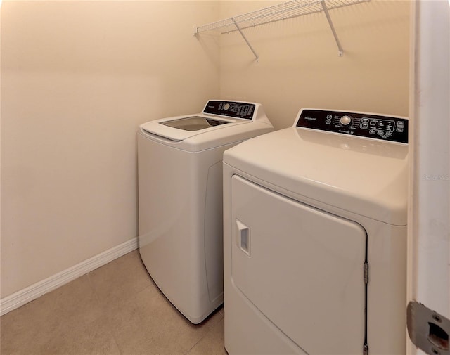 laundry area featuring washing machine and dryer and light tile patterned floors