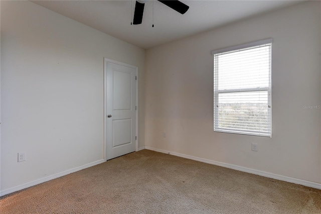 carpeted spare room featuring ceiling fan