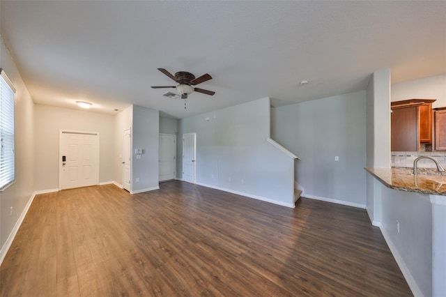 unfurnished living room with sink, dark hardwood / wood-style floors, and ceiling fan