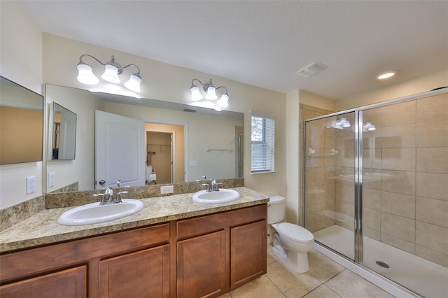 bathroom with toilet, vanity, tile patterned floors, and a shower with shower door