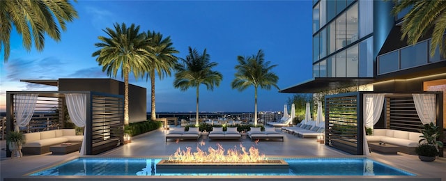 pool at dusk featuring an outdoor living space with a fire pit