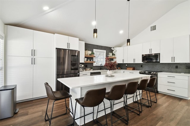 kitchen with pendant lighting, stainless steel appliances, and white cabinets