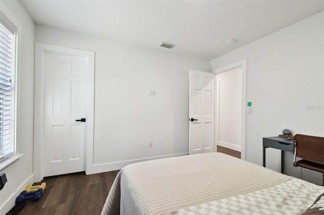 bedroom featuring dark hardwood / wood-style flooring and multiple windows