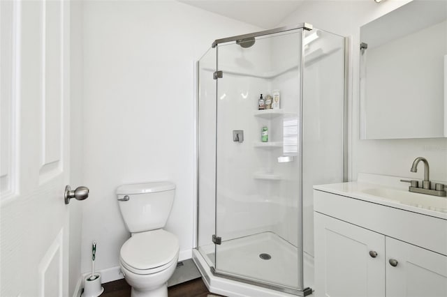 bathroom featuring vanity, a shower with shower door, and toilet