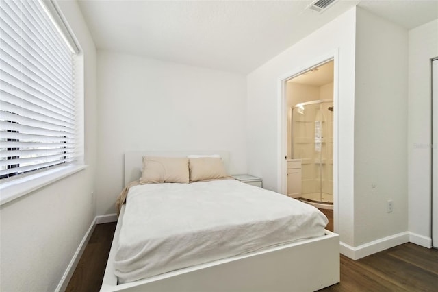 bedroom with dark hardwood / wood-style flooring and ensuite bath