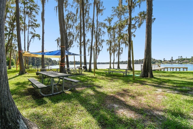 view of community with a water view and a yard