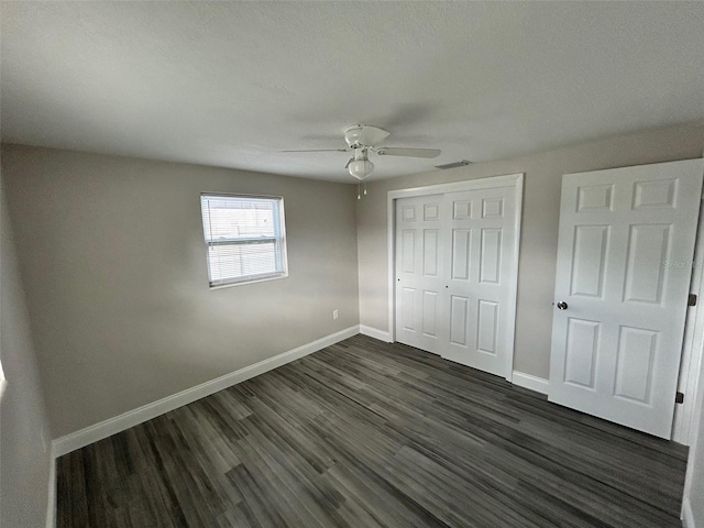 unfurnished bedroom featuring dark hardwood / wood-style floors, a closet, and ceiling fan