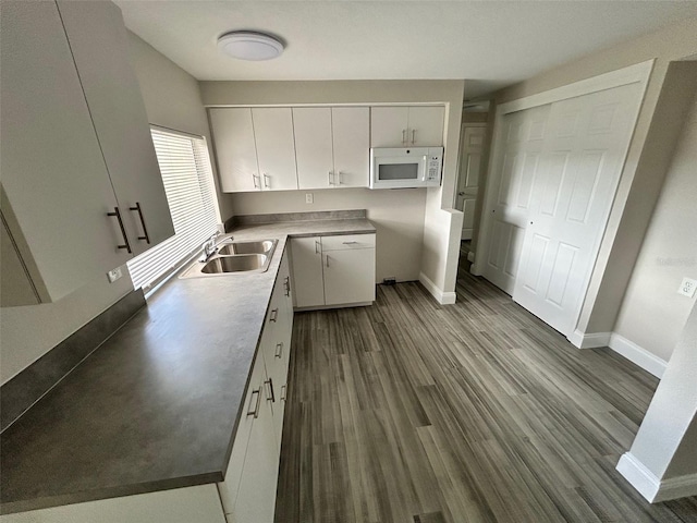 kitchen featuring white cabinets, sink, and dark hardwood / wood-style floors