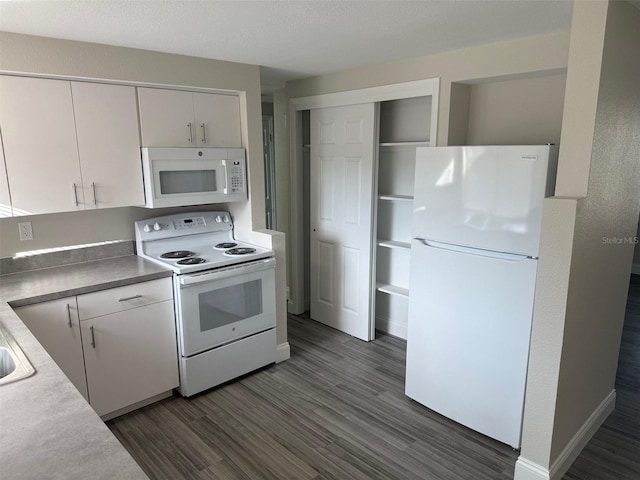 kitchen with dark hardwood / wood-style flooring, white appliances, and white cabinets