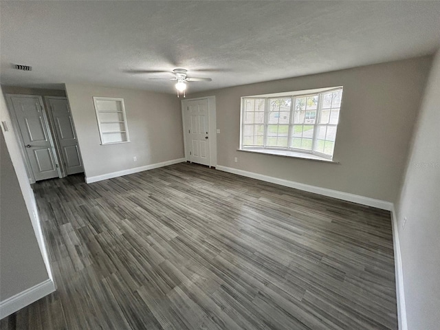 interior space with a textured ceiling, dark hardwood / wood-style floors, and ceiling fan