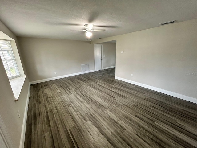 empty room featuring a textured ceiling, dark hardwood / wood-style floors, and ceiling fan