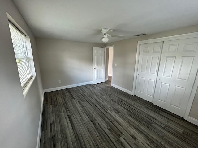 unfurnished bedroom with ceiling fan, a closet, and dark hardwood / wood-style flooring