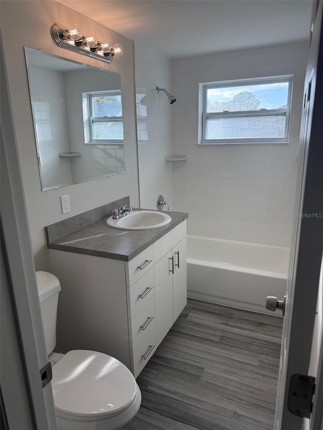 full bathroom featuring toilet, a wealth of natural light, and vanity