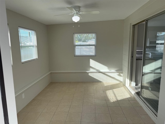 tiled spare room featuring ceiling fan